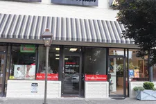 Thumbnail for State Farm insurance office storefront with striped awning, red signage, and brick exterior on sunny day