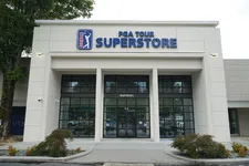 Thumbnail for Front entrance of PGA Tour Superstore with glass doors and signage on a cloudy day