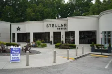 Thumbnail for Modern building exterior of Stellar Bodies wellness center with outdoor seating and Mai Thai restaurant sign.