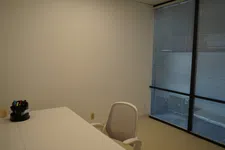 Thumbnail for Minimalist office with white desk, ergonomic chair, pen holder, and large windows with blinds.