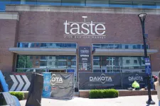 Thumbnail for Exterior of Taste Wine Bar and Market under construction with banners and signage at entrance in city setting.