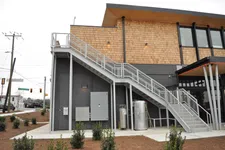 Thumbnail for Modern commercial building with exterior metal staircase leading to second floor under natural daylight