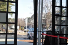 Thumbnail for View through glass doors showing parked car, street, trees, and clear sky outside on a sunny day