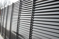Thumbnail for Black metal slatted fence with vertical supports creating a modern privacy barrier outdoors.
