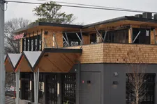 Thumbnail for Modern two-story building with wood siding and large windows housing Grindhouse restaurant.