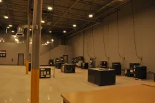 Thumbnail for Spacious industrial warehouse with multiple HVAC units and high ceilings under bright overhead lights.