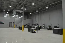 Thumbnail for Large industrial warehouse with HVAC units on a polished concrete floor under high ceiling lights