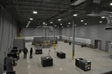 Thumbnail for Large industrial warehouse interior with HVAC units, concrete floor, exposed ceiling, and workers inside under bright lighting