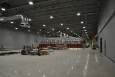 Thumbnail for Spacious industrial warehouse under construction with high ceilings and suspended ductwork and lighting
