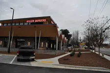 Thumbnail for Killer Burgers restaurant exterior with neon sign during cloudy day and parked black pickup truck