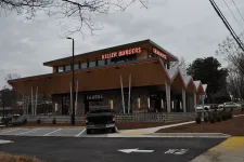 Thumbnail for Modern Killer Burgers Grindhouse restaurant with unique angular roof and outdoor lighting at dusk.