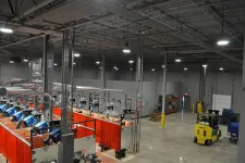 Thumbnail for Industrial warehouse interior with welding stations, bright overhead lights, and a yellow forklift on concrete floor