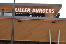 Thumbnail for Killer Burgers restaurant sign with modern wooden and metal building facade under an overcast sky.