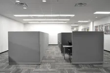 Thumbnail for Empty modern office with gray cubicles, carpeted floor, and bright overhead lighting in a clean workspace.