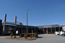 Thumbnail for Exterior view of Tulsa Welding School building with signage and parked cars under a clear blue sky.