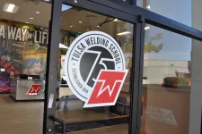 Thumbnail for Entrance glass door with Tulsa Welding School logo and interior showing workspace and wall art