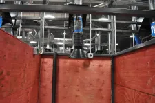 Thumbnail for Wooden enclosure with ventilation ducting and industrial ceiling in a spacious facility.