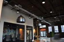 Thumbnail for Spacious modern office interior with industrial design, exposed ductwork, pendant lights, and meeting rooms.