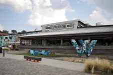 Thumbnail for Outdoor view of Chattahoochee Works food hall with mural, blue chairs, and large decorative letter W