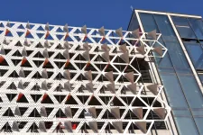 Thumbnail for Modern building facade with triangular geometric panels creating a dynamic pattern against a blue sky.