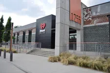 Thumbnail for Modern iHeart Media building entrance with concrete pillars and black and brick exterior at 1255 address.