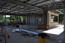 Thumbnail for Interior view of a building under construction with metal framing and construction materials scattered.