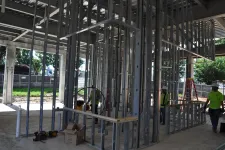 Thumbnail for Construction workers installing metal framing inside a building under construction with tools and materials around.
