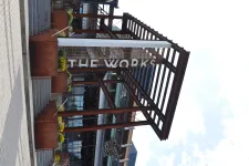 Thumbnail for Entrance to The Works building with modern industrial design and stairs under a bright sky
