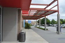 Thumbnail for Outdoor shopping plaza with HomeGoods and Walmart stores under red metal canopy and parking lot on a cloudy day