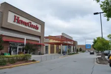 Thumbnail for Exterior view of HomeGoods store next to Walmart in a shopping plaza under a cloudy sky.