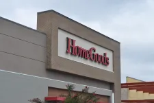 Thumbnail for Exterior view of a HomeGoods store sign on a brick and beige building under a cloudy sky.