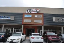 Thumbnail for Front view of a commercial building with parked cars and signs for Kumon, Elite Golf, OB/GYN, and dental offices.