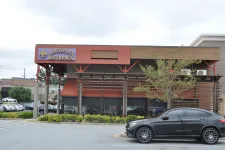 Thumbnail for Louisiana Bistreaux restaurant exterior with a parked black car and surrounding greenery in a shopping area.