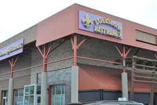 Thumbnail for Exterior view of Louisiana Bistreaux restaurant with purple and gold signage on a building corner.