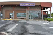 Thumbnail for Exterior view of Louisiana Bistreaux restaurant with empty parking lot on a cloudy day.