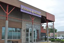 Thumbnail for Exterior view of Louisiana Bistreaux restaurant with purple sign and modern architectural design.