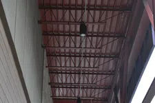 Thumbnail for View of industrial red metal ceiling with pipes and lighting fixtures under an open structure