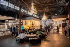Thumbnail for Indoor food market with people dining and walking under chandeliers and high ceiling lighting.