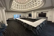 Thumbnail for Conference room with U-shaped tables and chairs under a decorative domed ceiling with natural light.