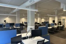 Thumbnail for Modern open office space with rows of desks, computer monitors, ergonomic chairs, and bright overhead lighting.