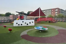 Thumbnail for Modern outdoor playground with colorful equipment, climbing tunnel, shaded area, and rubber safety flooring under clear sky