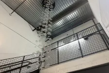 Thumbnail for Modern indoor stairwell with metal railings and hanging glass bubble chandelier under industrial ceiling.