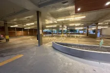 Thumbnail for Empty indoor parking garage with concrete pillars, yellow markings, and overhead fluorescent lights