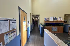 Thumbnail for Interior hallway of a childcare facility with informational boards, wooden doors, and an aquarium display.