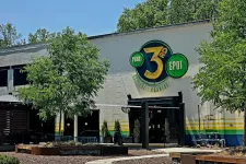 Thumbnail for Exterior of a building with a large colorful 3rd Spot logo, surrounded by trees and outdoor seating area.