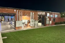 Thumbnail for Night view of Scofflaw Brewing Co building with exposed brick, electrical panels, and green lawn in front.