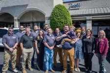 Thumbnail for Group photo of Dayco Systems employees standing outside their office building on a sunny day.