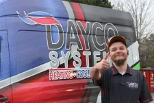 Thumbnail for Smiling technician in Dayco Systems uniform gives thumbs up next to colorful Dayco Systems HVAC service van.