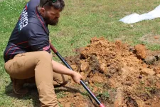 Thumbnail for Man in work clothes digging a hole in the ground with a shovel on a grassy area to fix plumbing leak during daytime