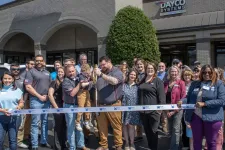 Thumbnail for Group of people at a ribbon-cutting ceremony outside Dayco Systems building on a sunny day.